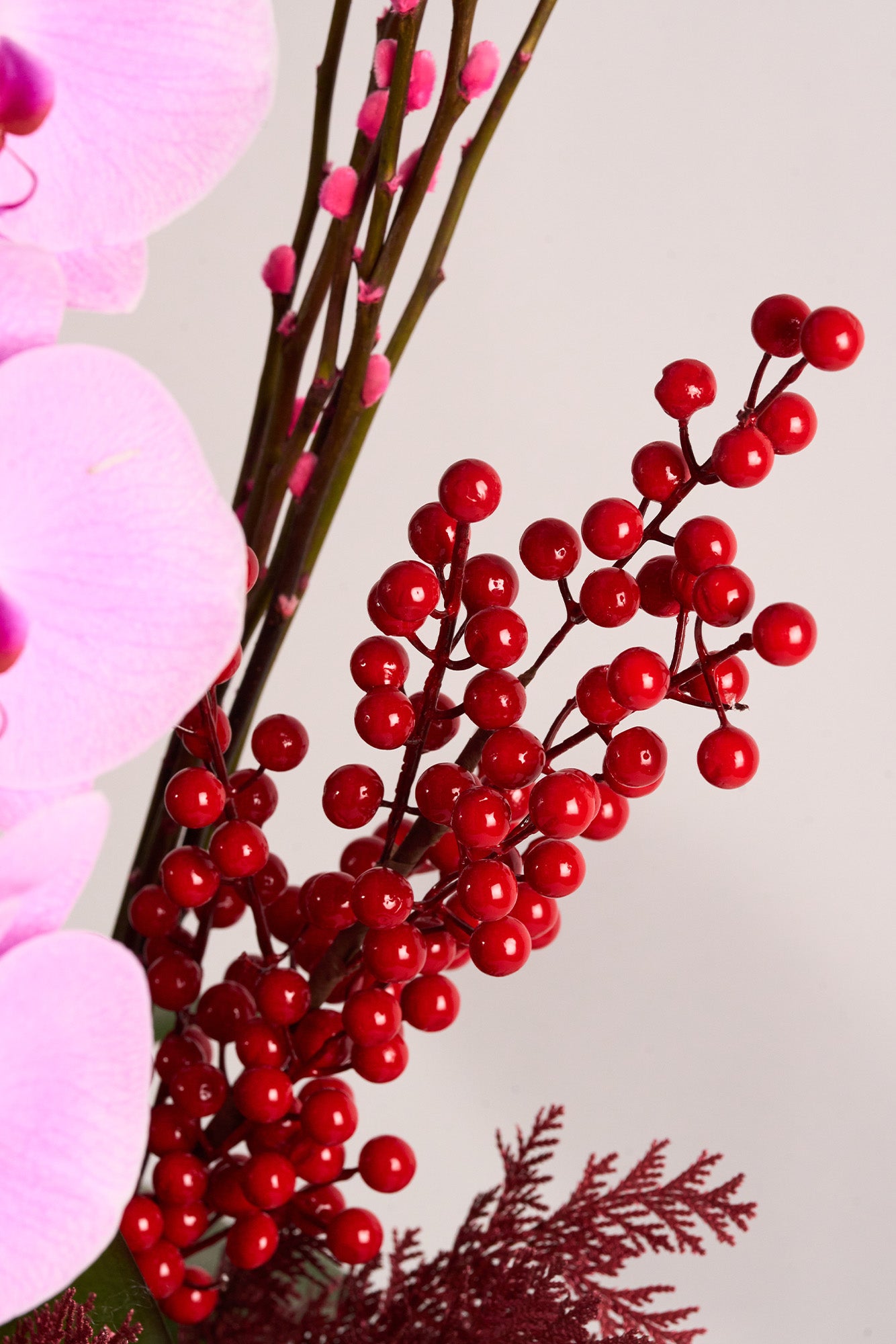 Radiant Year floral arrangement with pink Phalaenopsis orchids, red willow branches, and festive berries, symbolizing renewal, vibrancy, and prosperity for Lunar New Year 2025. Created by Just Bloom Hong Kong.